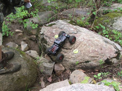1996 Ford Bronco - A remote control rock crawler navigates a rocky terrain, with yellow markers indicating a course.
