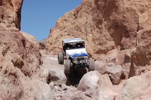 1985 Ford Bronco - This vehicle is navigating a challenging off-road trail through a desert canyon.