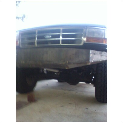 1993 Ford Bronco - Close-up of a Ford truck's grille and a custom-fabricated bumper, showing the front end.