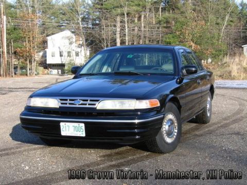 2001 Ford Crown Victoria - This black 1996 Ford Crown Victoria police car is shown from the front 3/4 angle on a gravel lot.