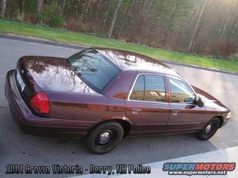 2001 Ford Crown Victoria - This maroon 2001 Ford Crown Victoria, previously used by Derry, NH Police, is shown from a 3/4 front angle.