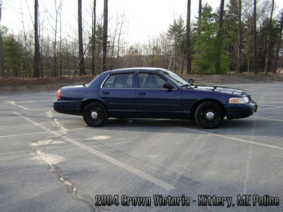 Dark blue police sedan parked in a lot, text overlay reads '2004 Crown Victoria - Kittery, ME Police'