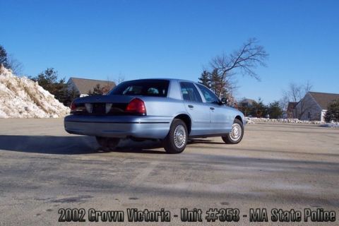 2001 Ford Crown Victoria - A light blue sedan, identified as a 2002 Crown Victoria, is parked outdoors on a sunny day, with a pile of snow to the left.
