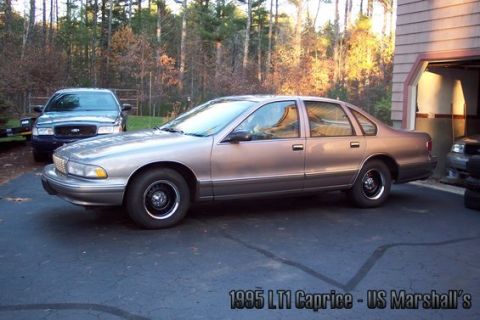2001 Ford Crown Victoria - A 1995 LT1 Caprice sedan, identified as US Marshall's vehicle, is parked in a driveway.