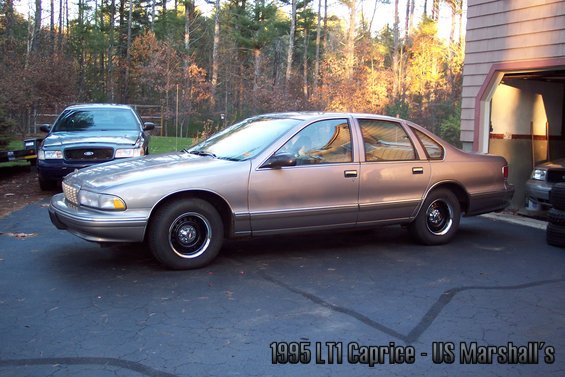 Side view of a 1995 Chevrolet Caprice sedan parked next to a Ford Crown Victoria