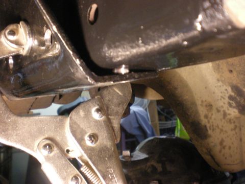 1993 Ford Bronco - A close-up view of vehicle frame and suspension components, with vise grips attached.