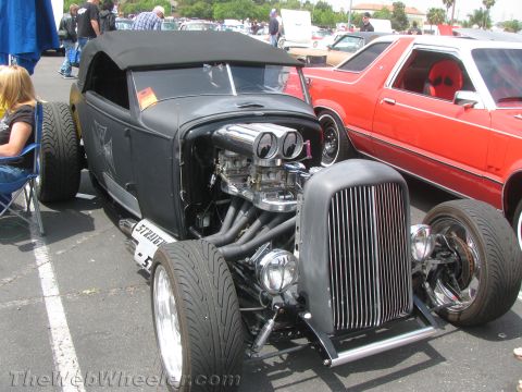 1968 Ford Mustang - A custom hot rod is displayed at an outdoor car show, parked next to another vehicle.
