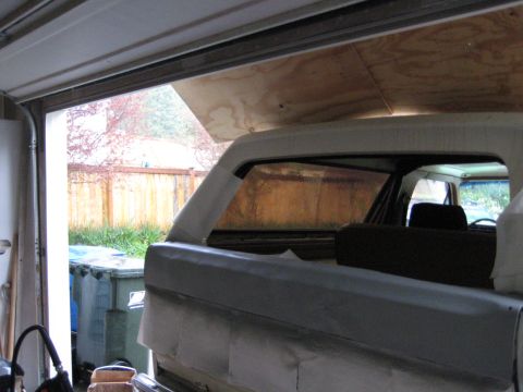1980 Ford Bronco - Rear view of a white 1980 Ford Bronco in a garage, showing its body style and undergoing restoration.