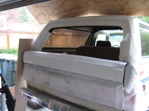 1980 Ford Bronco - The rear of a Ford Bronco is shown, covered in tape and paper in preparation for painting.