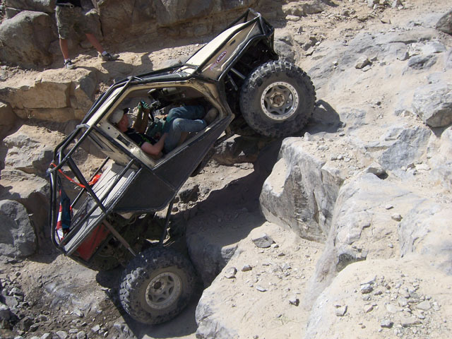 1993 Toyota 4Runner modified for off-roading, tilted on its side on a rocky incline