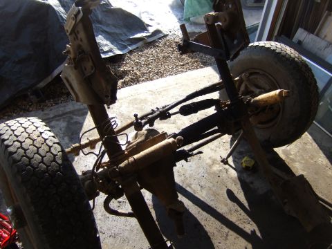 1989 Ford Bronco - Close-up view of a vehicle's front axle and suspension components, showing rust and wear.