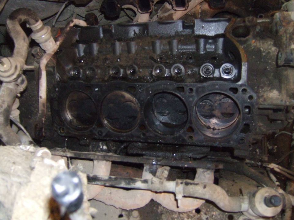 Engine block with pistons visible, showing wear