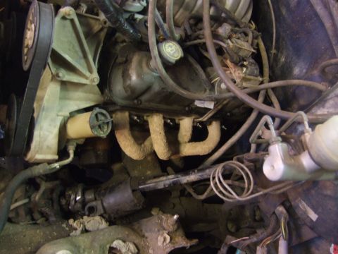 1989 Ford Bronco - Close-up view of an engine bay, highlighting the exhaust manifold and associated components.