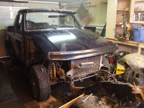 1989 Ford Bronco - This 1989 Ford Bronco is undergoing repairs in a garage, with its front end partially dismantled.