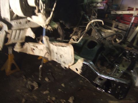 1989 Ford Bronco - Undercarriage components, possibly from a Ford Bronco, are visible in this workshop setting.