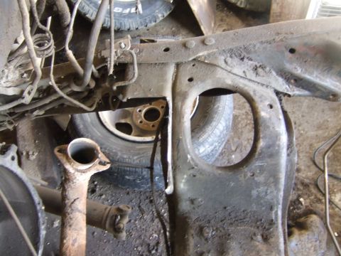 1989 Ford Bronco - Close-up view of a vehicle's frame and exhaust pipe, with a tire visible in the background.
