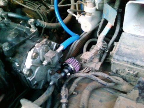 1995 Ford Bronco - Close-up of engine bay components, including a small aftermarket air filter and blue tubing.