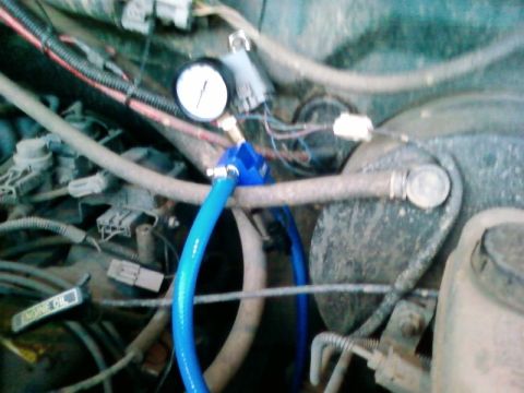 1995 Ford Bronco - A pressure gauge is attached to a blue hose in the engine compartment.