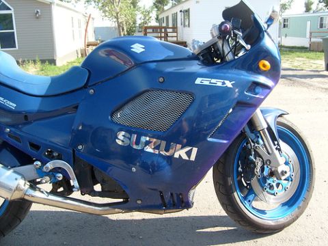 1988 Suzuki GSX600F Katana - A blue Suzuki motorcycle is shown from the front three-quarter view, with its distinctive fairing and logos clearly visible.