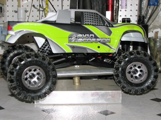 RC rock crawler truck, neon green and gray graphics, "AX10 SCORPION" text