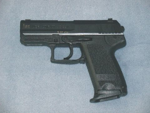 2003 Ford Crown Victoria - A black handgun is shown against a blue textured background.