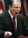1996 Ford Bronco - A man in a suit and tie is captured mid-speech, with his mouth open wide.
