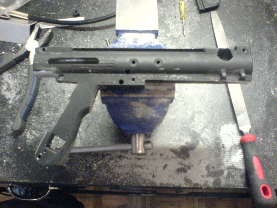Firearm receiver being worked on in a vise with a file.