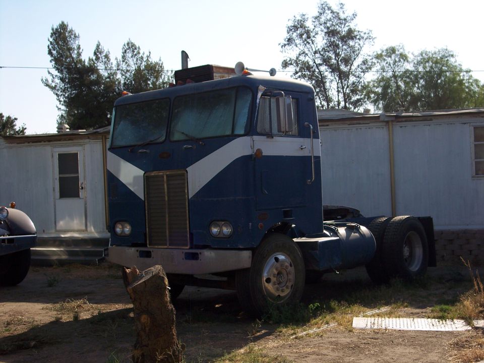 Blue and white semi-truck cab parked outdoors.
