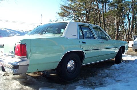 2001 Ford Crown Victoria - This sedan has a distinctive body style and vinyl roof, suggesting an older model year.