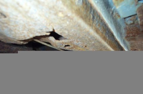 2001 Ford Crown Victoria - Undercarriage shows significant rust and holes in the frame.