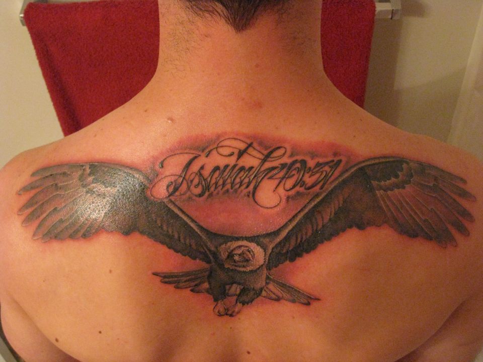 Finished black-and-gray eagle tattoo with script lettering on a man's upper back