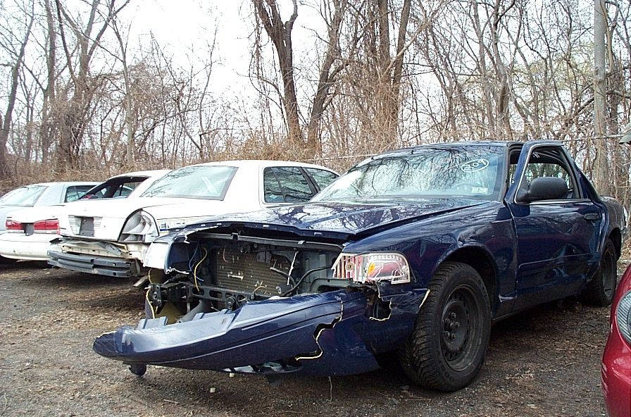 Blue 2001 Ford Crown Victoria with damaged front end and side