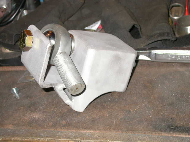 Custom metal bracket with spherical bearing and bolt assembly on workbench