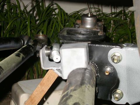 1990 Ford Bronco - A close-up view of a custom steering linkage assembly attached to a vehicle's axle. The assembly includes various metal brackets, bolts, an…
