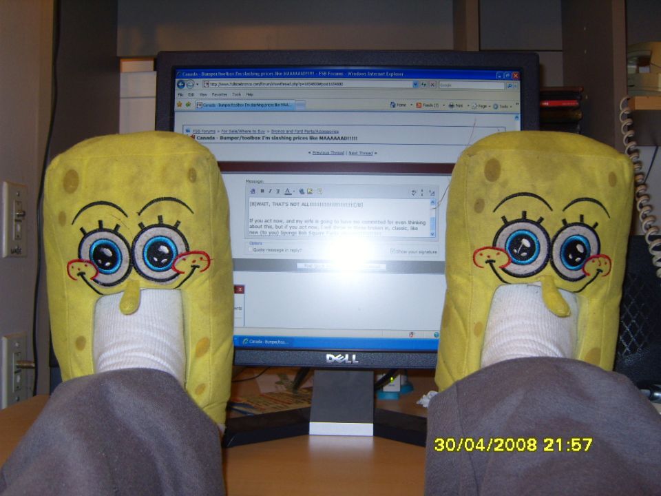 SpongeBob SquarePants slippers on feet in front of a computer monitor displaying a web forum