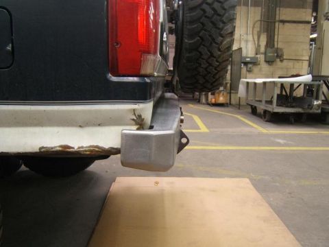 1993 Ford Bronco - The rear of an SUV shows a rusty bumper and a spare tire mounted externally.