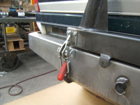 1993 Ford Bronco - Close-up view of a rear bumper assembly, a tow hitch and attached safety chain.