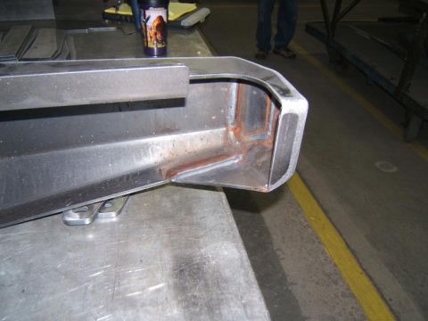 1993 Ford Bronco - A close-up view of a steel bumper corner, showing signs of rust and attachment points.