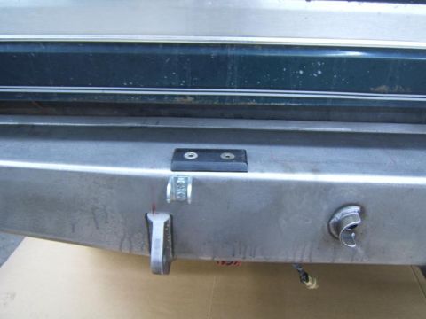 1993 Ford Bronco - Close-up of a metal rear bumper with a tow hook and a lock mechanism visible.