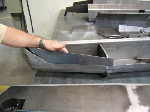 1993 Ford Bronco - Metal fabrication of vehicle bumper components is shown on a workbench.