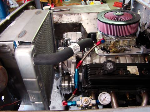 1948 Jeep Wrangler - Close-up view of an engine bay, showing a radiator, carburetor, and fuel lines.