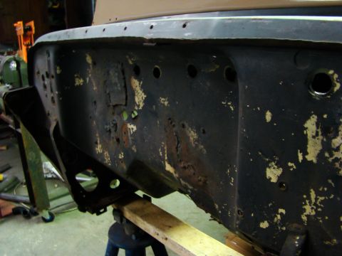 1948 Jeep Wrangler - This heavily rusted vehicle frame section shows significant wear and tear, with peeling yellow paint over a black base.