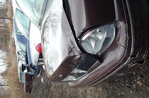 2001 Ford Crown Victoria - A row of vehicles, with the closest one showing significant front-end damage.