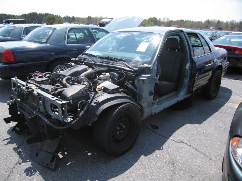 2001 Ford Crown Victoria - This 2001 Ford Crown Victoria is missing its front bumper and hood, revealing the engine compartment.