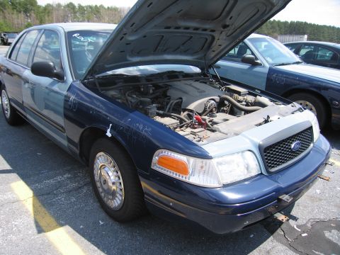 2001 Ford Crown Victoria - Front view of a 2001 Ford Crown Victoria with its hood open, revealing the engine compartment.