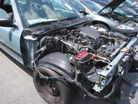2001 Ford Crown Victoria - The engine compartment of a car is exposed, with the front bumper and grille removed, revealing the engine and associated components.