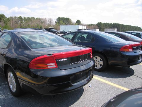 2001 Ford Crown Victoria - A black Dodge Intrepid is parked in a lot next to other vehicles.