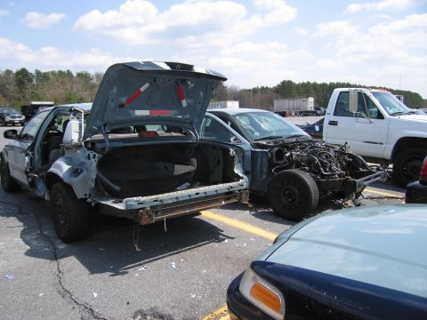 2001 Ford Crown Victoria - This 2001 Ford Crown Victoria is heavily damaged and stripped down, with its trunk open.