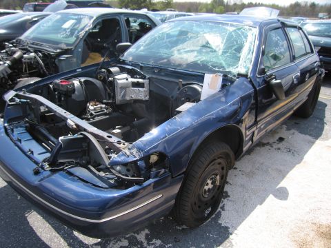 2001 Ford Crown Victoria - This blue 2001 Ford Crown Victoria shows significant damage to its front end and a shattered windshield, indicating it has been in a collis…
