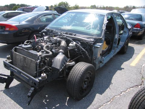 2001 Ford Crown Victoria - This 2001 Ford Crown Victoria is missing its front bumper and hood, showing the engine bay.